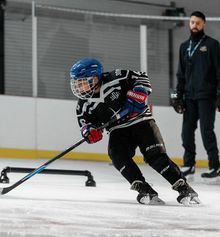 A kid practicing with coach Nick Orlando at Hockey Etcetera